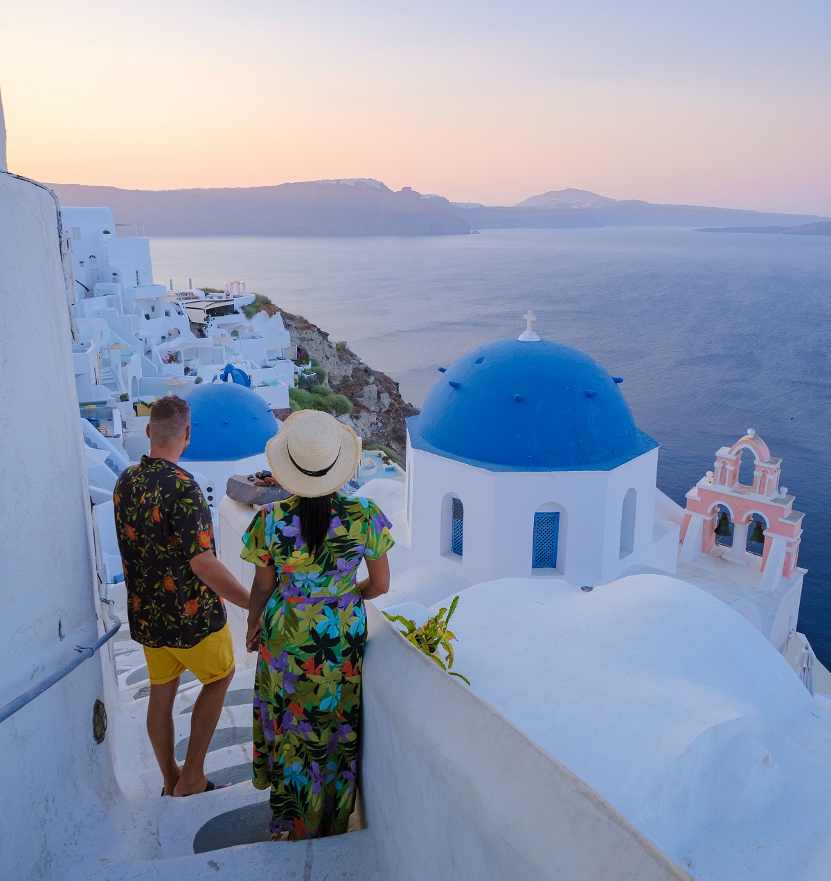 Couple walking at the Greek village of Oia Santorini Greece, men and women on vacation in Greece