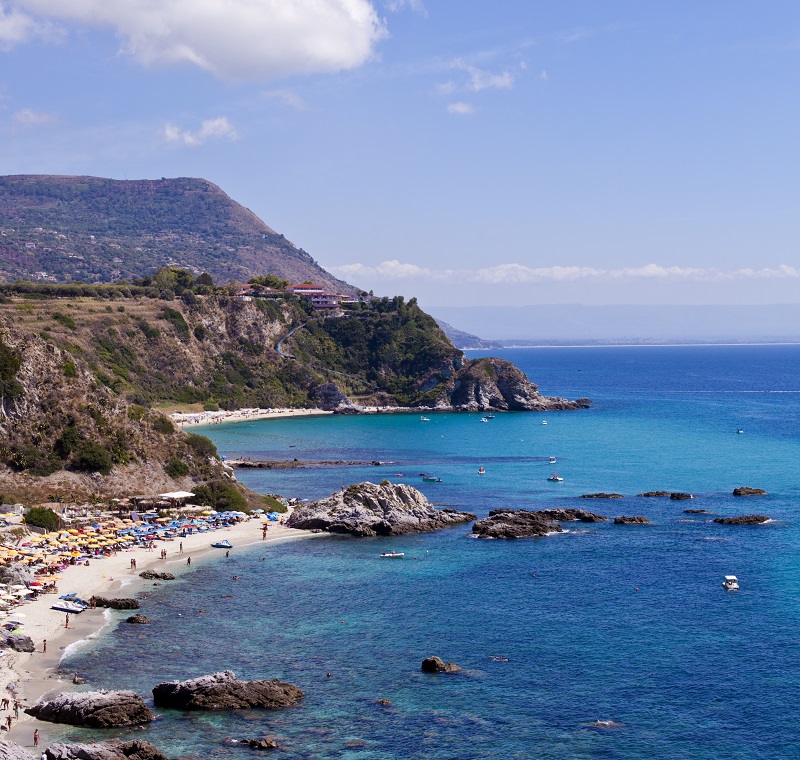 View of turquoise gulf bay, sandy beach, green mountains and pla