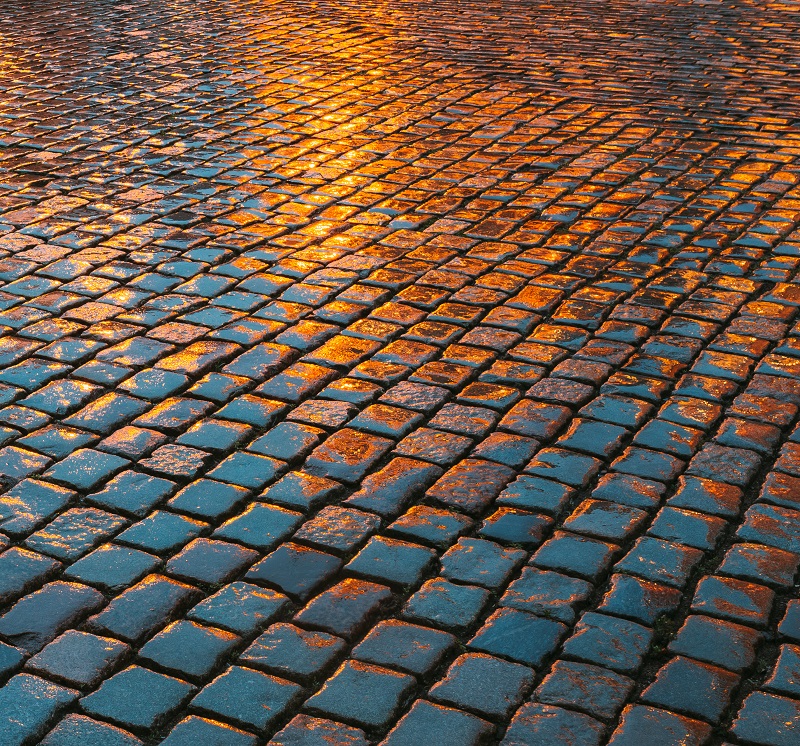 Old Streets Cobblestone Abstract Background. Wet Stones In Eveni