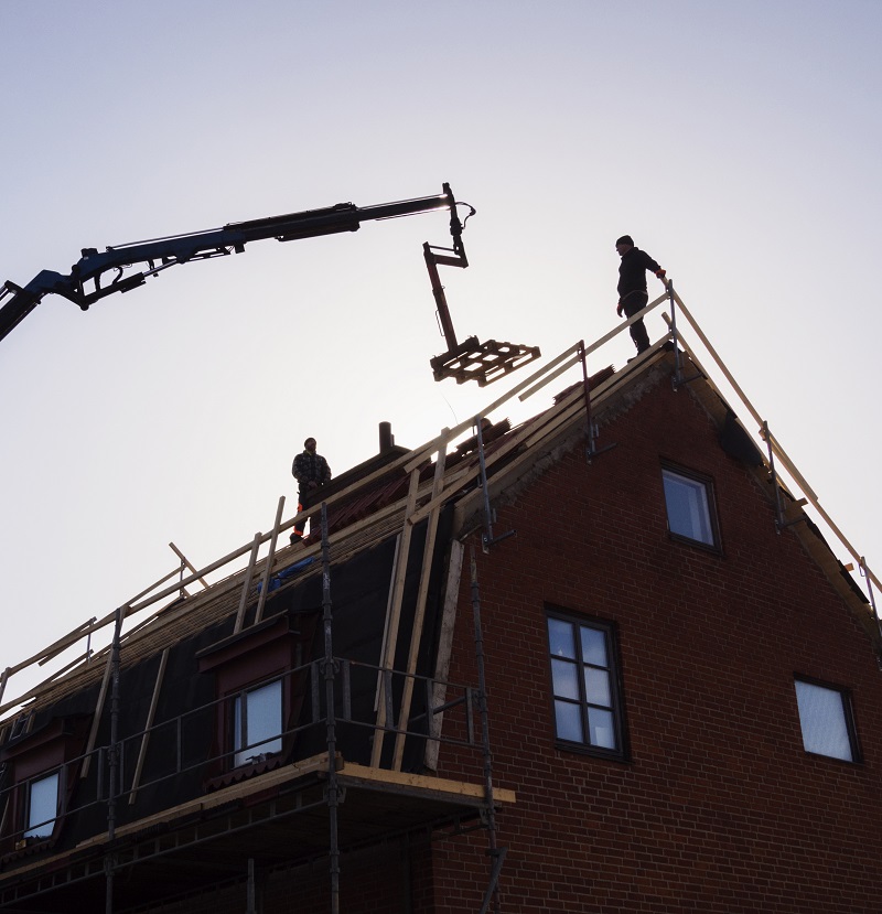 Silhouette of men and crane at construction site