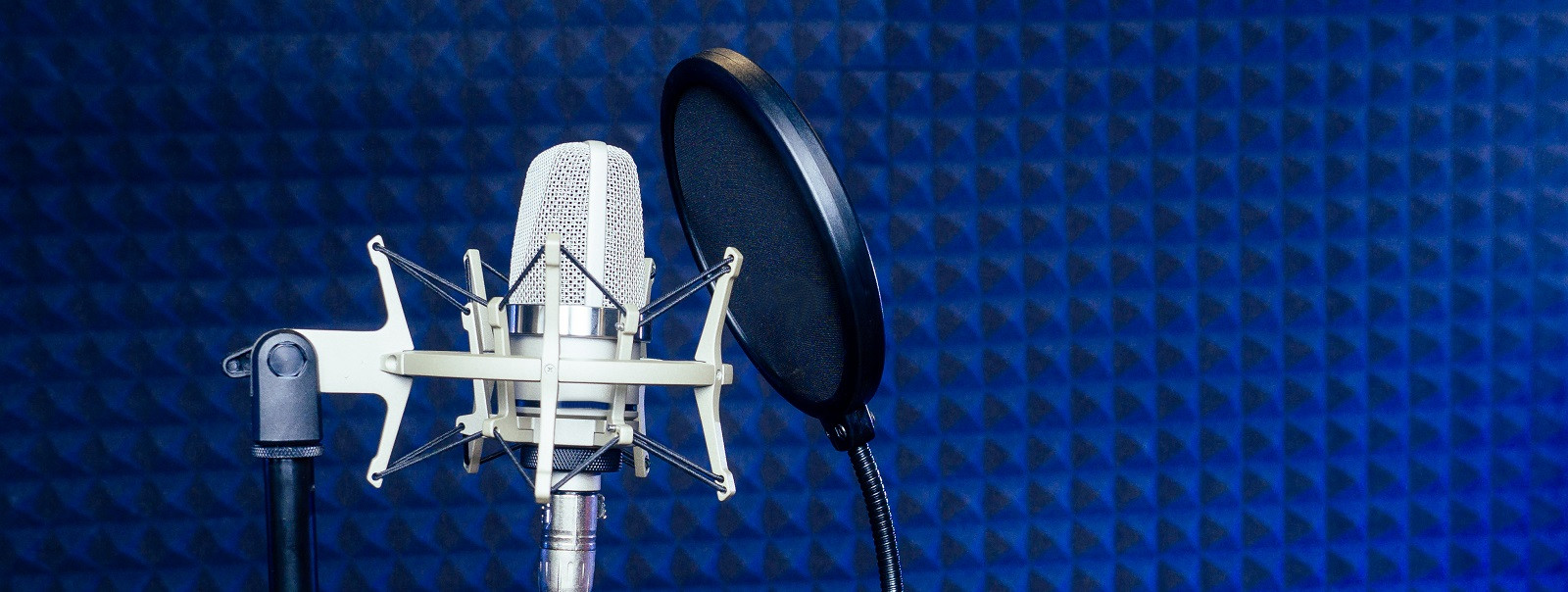 Microphone and headphone in a recording studio soundproof wall.